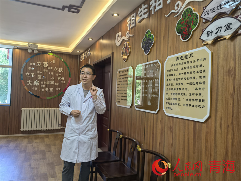 马房健正在为来访者介绍卫生院的特色诊疗服务。人民网马可欣摄